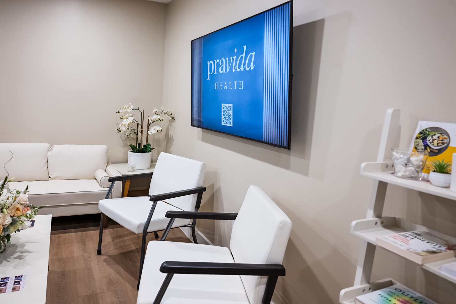 Pravida Health waiting room with branded digital display and modern furnishings